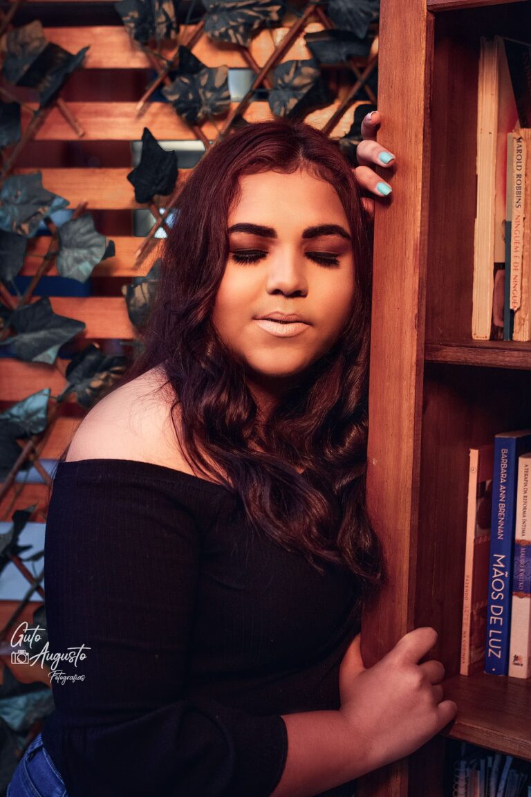 Alana em seu ensaio de 15 anos em Guaíba, capturando um momento autêntico e contemplativo entre livros
