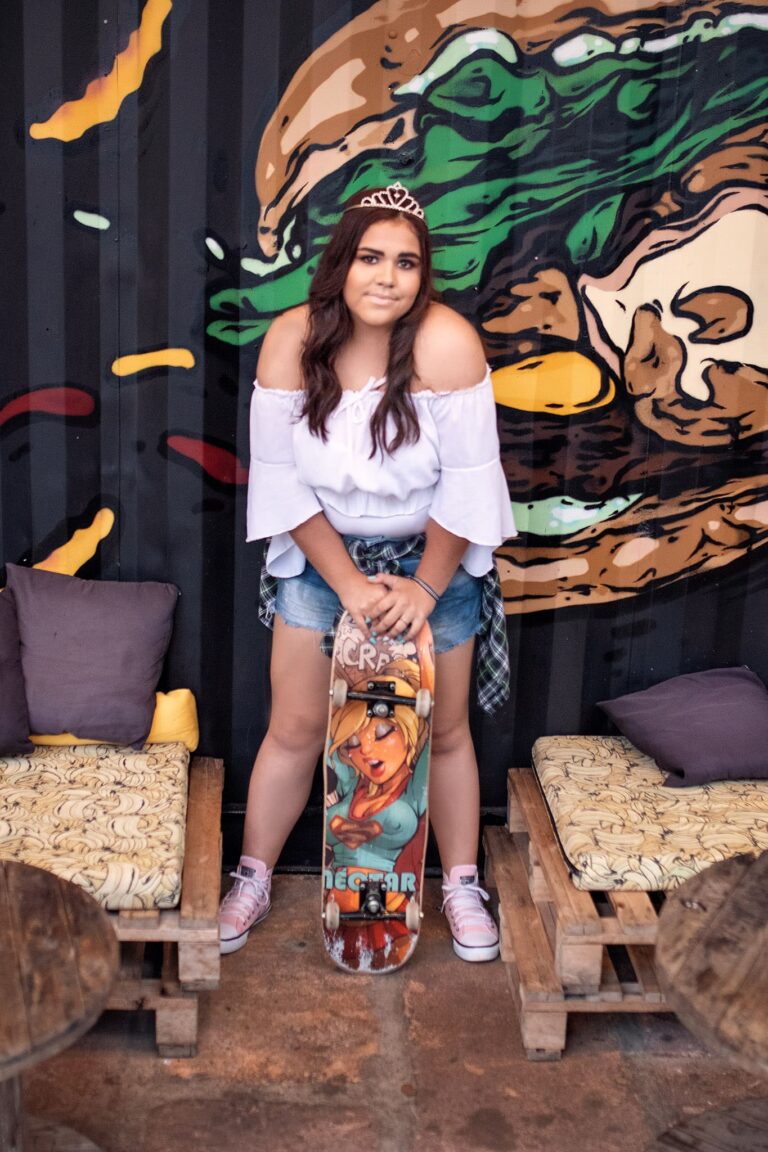 Alana posando com skate em ambiente urbano durante seu ensaio de 15 anos em Guaíba, capturando seu estilo descontraído e moderno