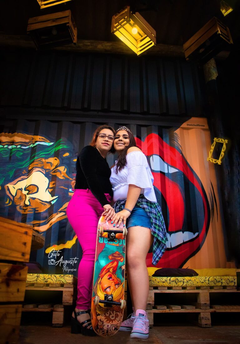 Alana em seu ensaio de 15 anos, posando com skate em um cenário urbano vibrante, fotografia de Guto Augusto
